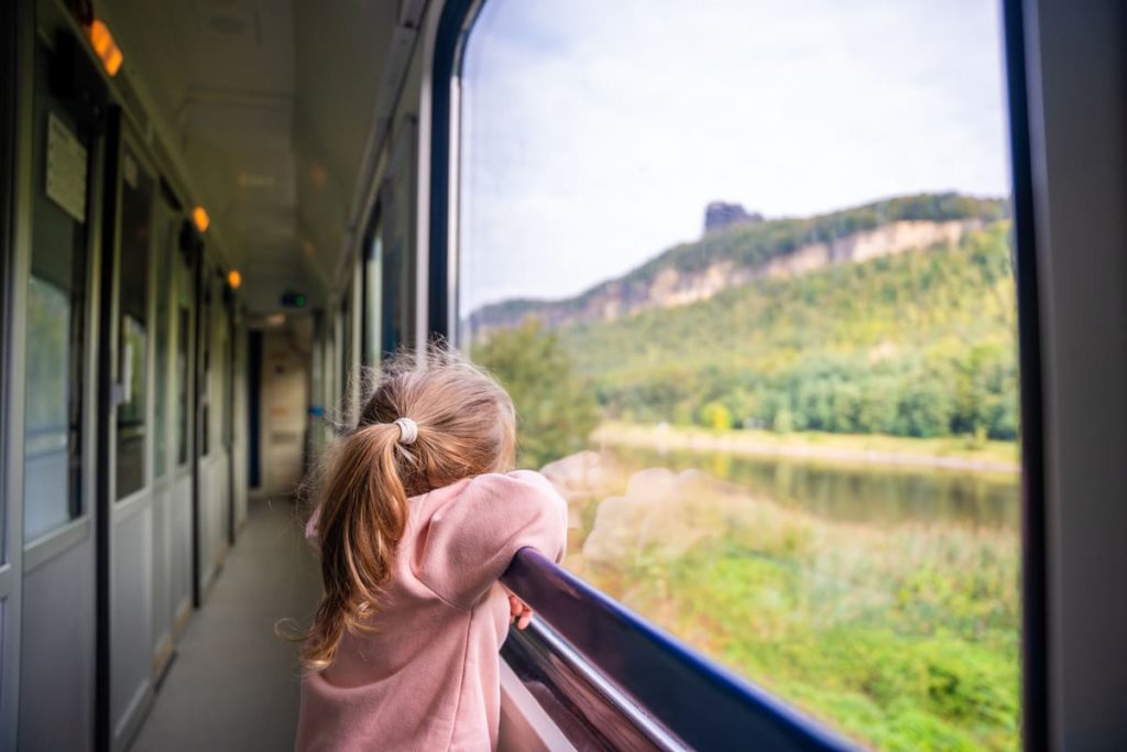 niña mirando por la ventana de un tren qué es el turismo sostenible